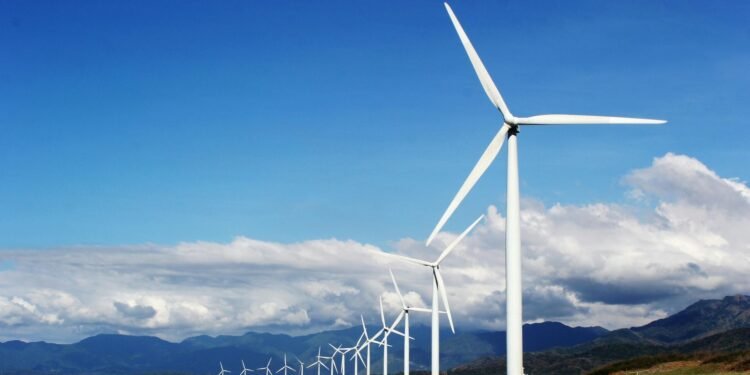 A row of wind turbines on a sandy coastline under a clear blue sky, promoting renewable energy. Sustainability: Why It Matters for Our Future