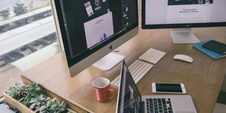 Sleek office desk setup featuring Apple computers and greenery for a modern work environment. Understanding Digital Adoption for Better Technology Use