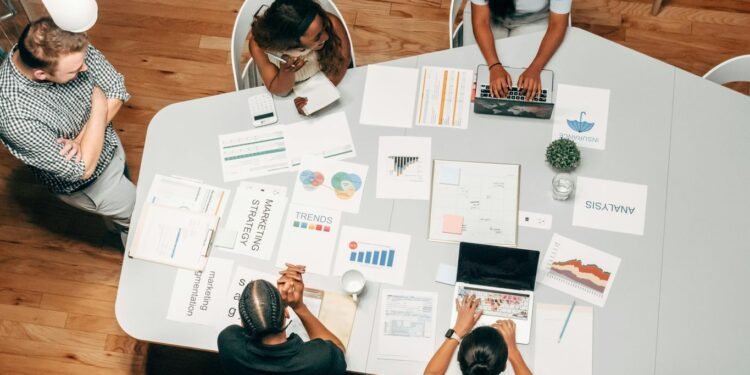 A diverse group working on marketing strategies with charts and laptops in an office setting. best SEO tools