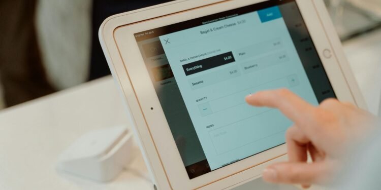 A person uses a tablet-based point-of-sale system by selecting options on a touchscreen device. best ecommerce tools